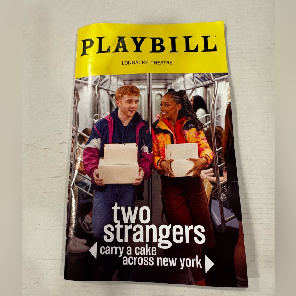 Two Strangers Carry A Cake Across New York Broadway Playbill December 2025